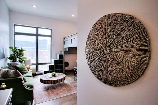Living room with circular wall art and city view at The Traveler Apartments, Omaha