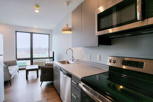 Open kitchen and living area with large window at The Traveler Apartments, Omaha, NE