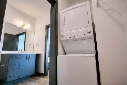 In unit stacked washer and dryer in alcove at The Traveler Apartments, Omaha, 68131