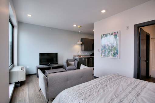 Studio apartment with kitchenette and gray sofa at The Traveler Apartments, Omaha, Nebraska
