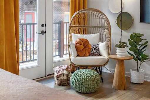A room with a chair, a table, and a plant.