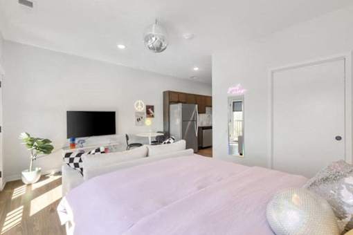 A bedroom with a large bed and a flat screen TV.