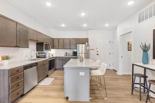 A kitchen with a white island and wooden cabinets.