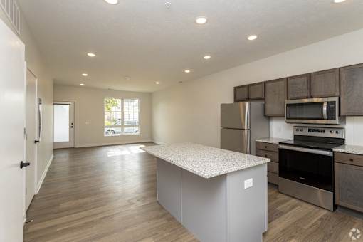 A kitchen with a white countertop and stainless steel appliances.