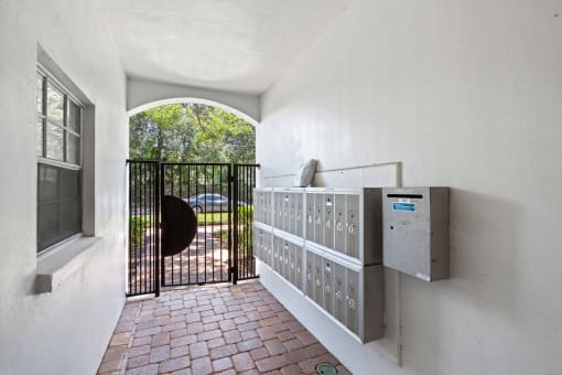 a gate opens to a driveway with a car in the distance