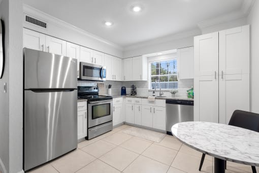 a kitchen with white cabinets and stainless steel appliances