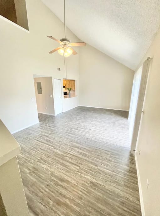 an empty living room with a ceiling fan