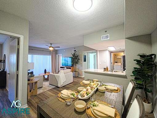 A dining room with a table set for a meal.