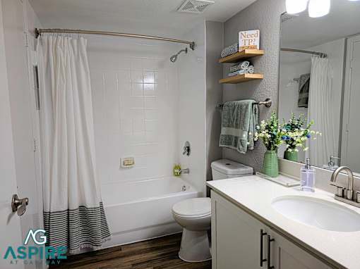 A bathroom with a white shower curtain, a toilet, a sink, and a mirror.