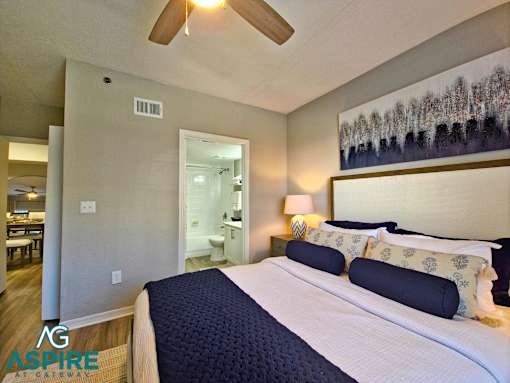 A bedroom with a large bed and a ceiling fan.
