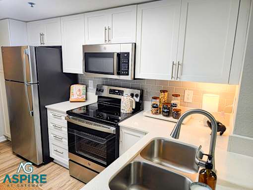 A kitchen with white cabinets and a stainless steel refrigerator.