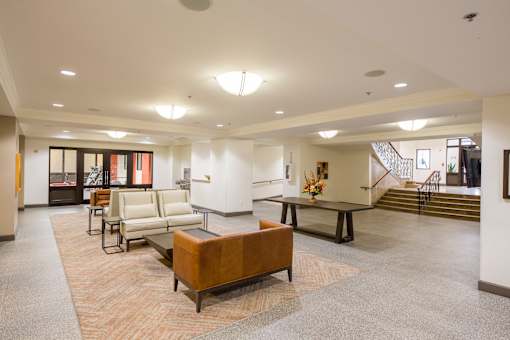 A spacious living room with a brown sofa and a coffee table.
