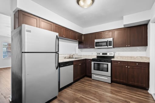 a kitchen with dark wood cabinets and stainless steel appliances