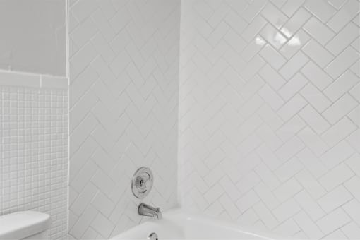 a bathroom with a white tub and a white toilet
