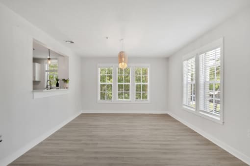 a living room with white walls and a large window