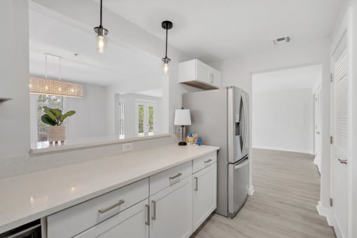 a kitchen with white cabinets and a stainless steel refrigerator