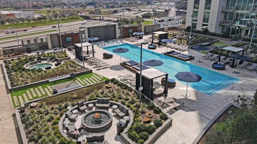 Aerial view of the pool courtyard surrounded by greenery and lounge areas in Houston, TX.