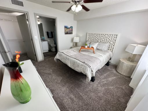 a bedroom with a bed and a vase on the floor