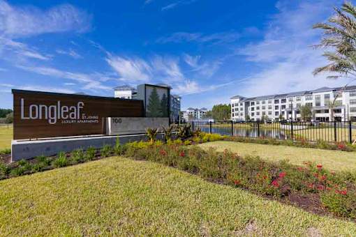 Inviting entrance to Longleaf at St. Johns Apartments, St. Johns, FL, featuring lush landscaping