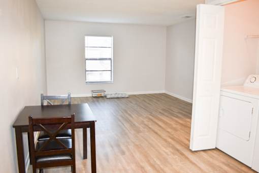 A room with a table and chairs and a window.