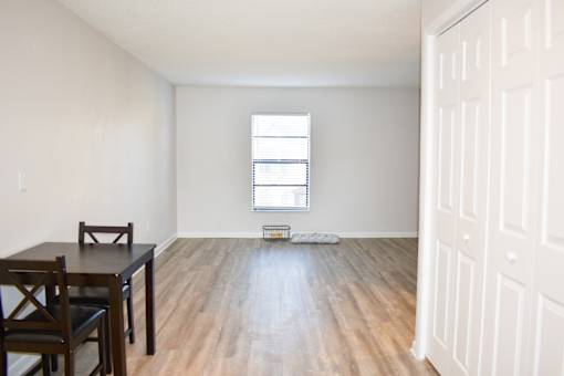 A room with a wooden floor and a table with chairs.