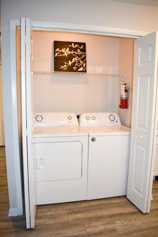 A white cabinet with a door open in a room.