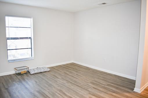 A room with a window and a basket on the floor.