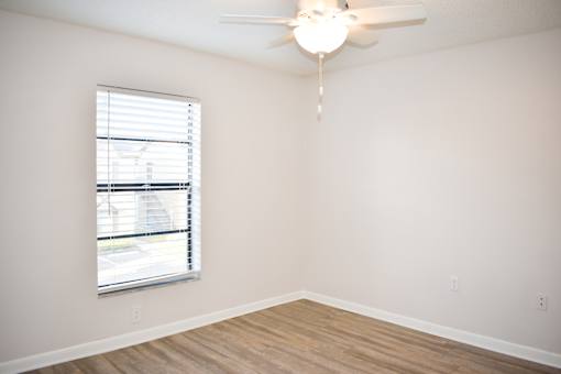 A room with a window and a ceiling fan.