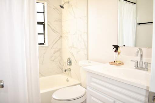A white bathroom with a toilet, sink, and bathtub.