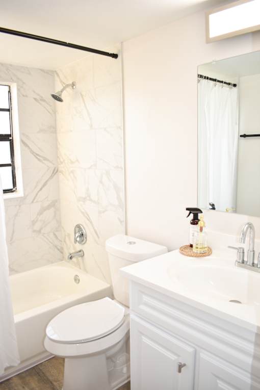A white bathroom with a toilet, sink, and bathtub.