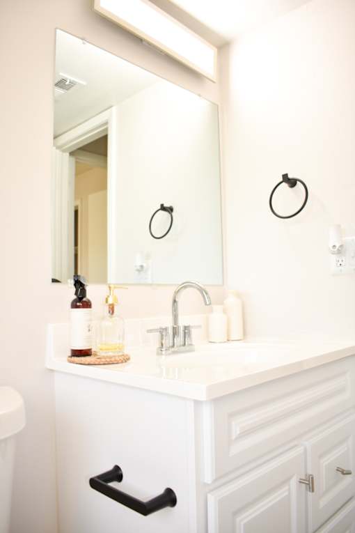 A bathroom with a white sink and a mirror above it.