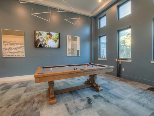 a pool table in a game room with windows
