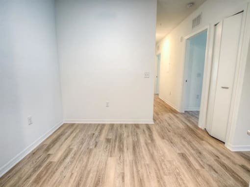 a empty room with a wood floor and white walls