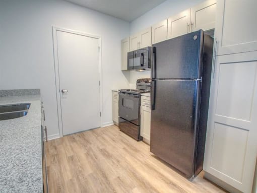 a kitchen with a refrigerator and a stove and