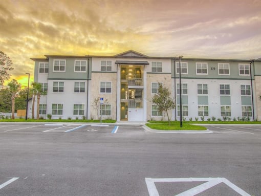 an empty parking lot in front of an apartment building