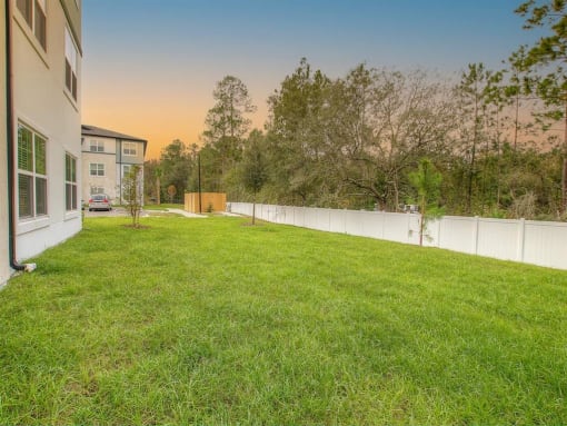 the backyard of a house with a yard and a fence
