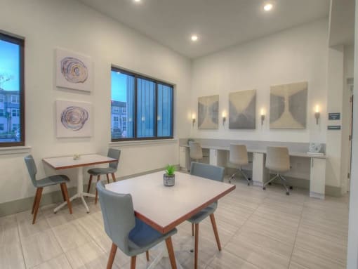 a dining room with tables and chairs and paintings on the wall