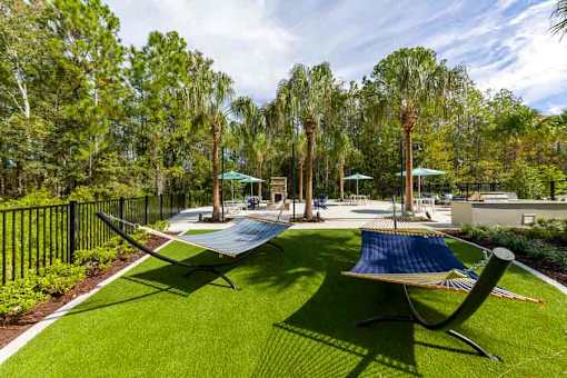 Relaxing hammocks at Longleaf at St. Johns Apartments, St. Johns, FL, surrounded by greenery