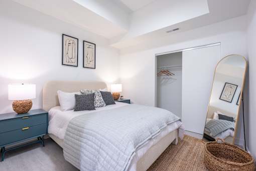 A bedroom with a bed, dresser, and mirror.