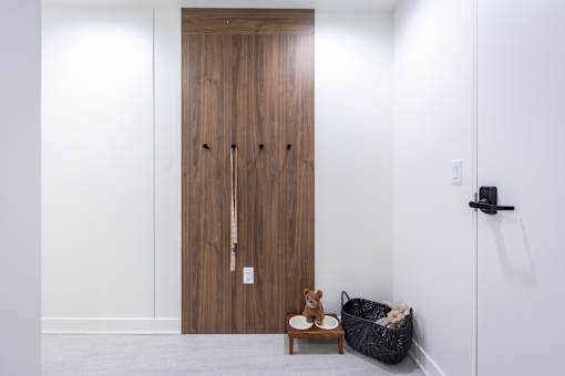 A room with a brown door and a teddy bear on a table.