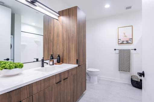 A bathroom with a white counter top and a white toilet.