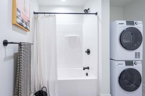 A white bathroom with a washer and dryer.