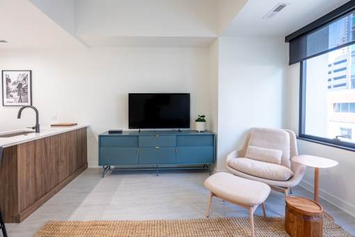 A living room with a television, a chair, and a cabinet.