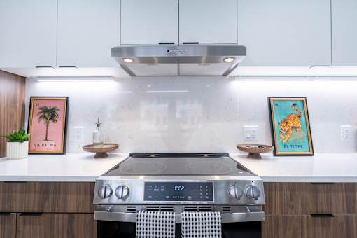 A modern kitchen with a stove top oven and a range hood above it.