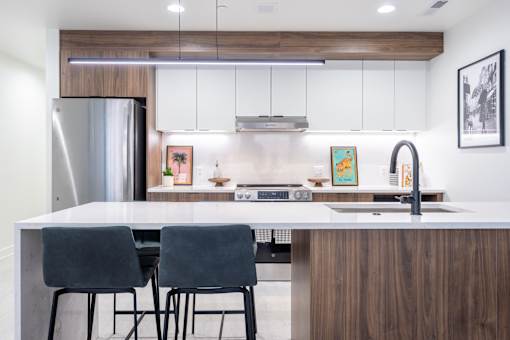 A modern kitchen with a white countertop and a sink.