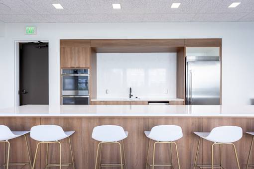 A kitchen with white chairs and a wooden counter.