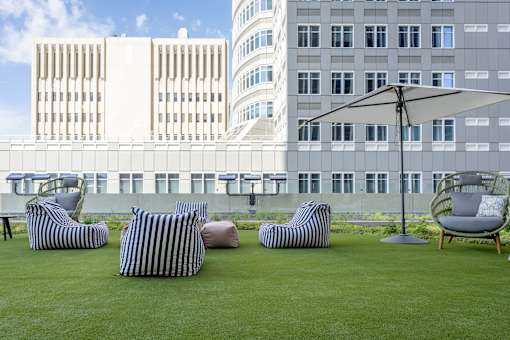 A patio with striped chairs and a striped ottoman.