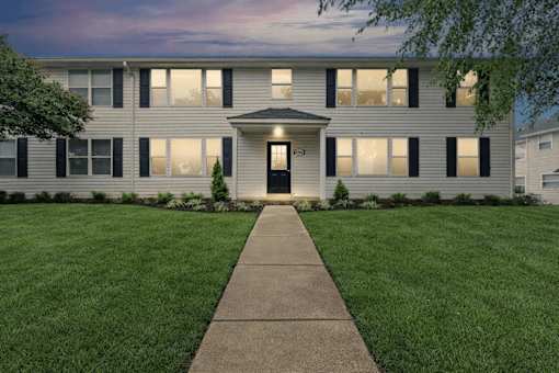 A building with a black door and windows with shutters.