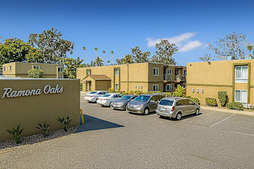Image of apartment building exterior with parking lot located at Ramona Oaks in Riverside, CA