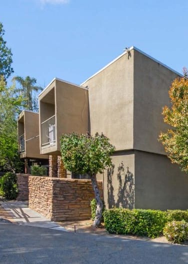 Image of modern apartment with a flat roof and a stone wall  located at Ramona Oaks in Riverside, CA